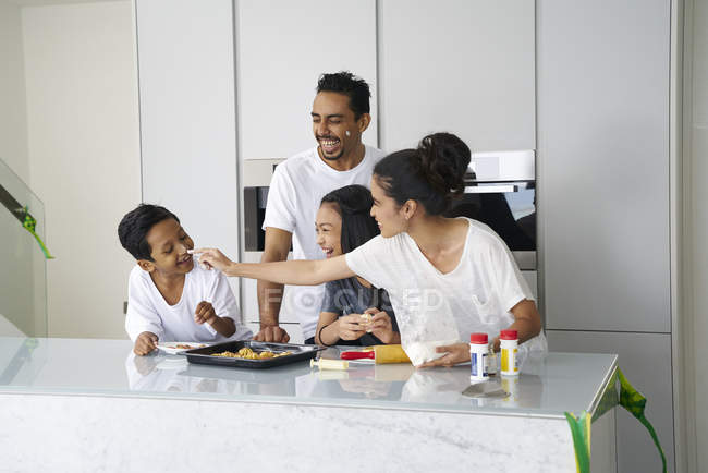 Young asian family celebrating Hari Raya together at home and cooking traditional dishes — Stock Photo