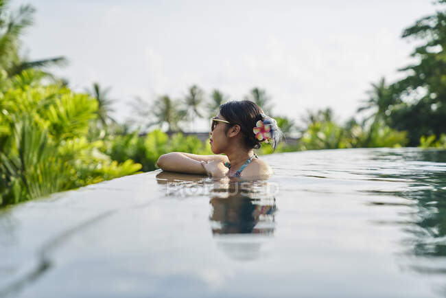 Junge asiatische Frau, die in einem Pool entspannen — Stockfoto