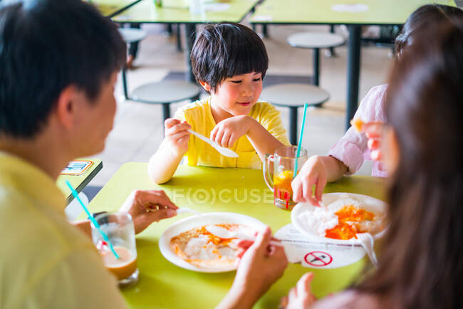 Родина їсть індійські делікатеси в кафе. — стокове фото