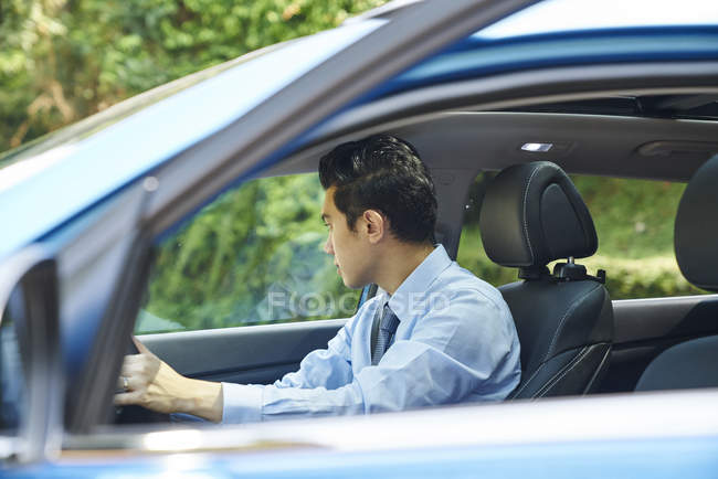 Молодий чоловік водій в машині, вид збоку — стокове фото
