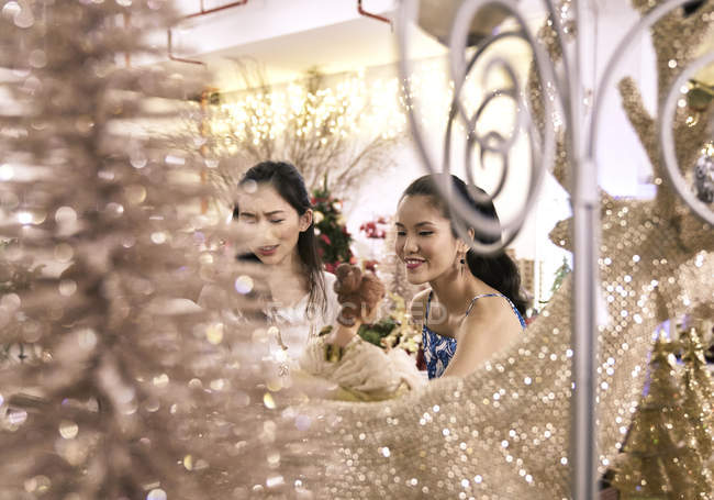 Zwei junge Asiatinnen shoppen zu Weihnachten gemeinsam in Einkaufszentrum — Stockfoto
