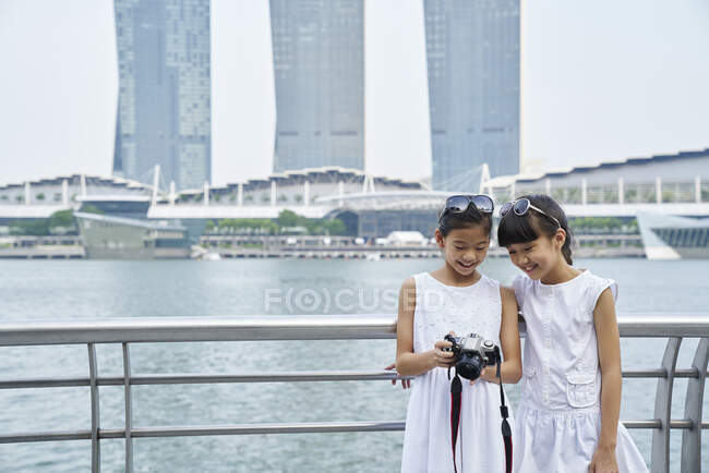 Dos hermanas jóvenes compartiendo un momento en su DSLR - foto de stock