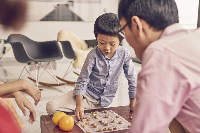 Feliz família asiática a passar tempo juntos e jogar o jogo de tabuleiro — Fotografia de Stock