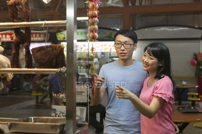 Asiático pareja juntos en café para la comida - foto de stock