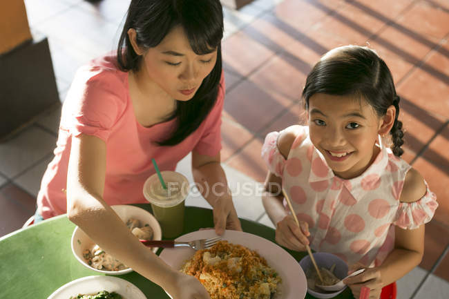 Happy asian family eating together in cafe — Stock Photo