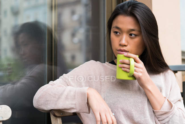 Mujer china con un café en casa - foto de stock