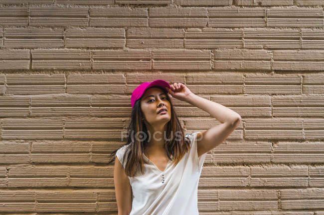 Jovem atraente asiático mulher com rosa cap — Fotografia de Stock