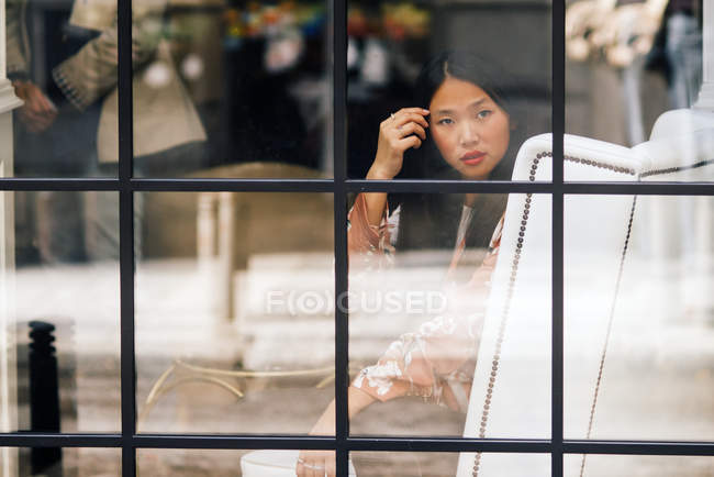 Piuttosto lunghi capelli donna cinese ritratto attraverso la finestra — Foto stock