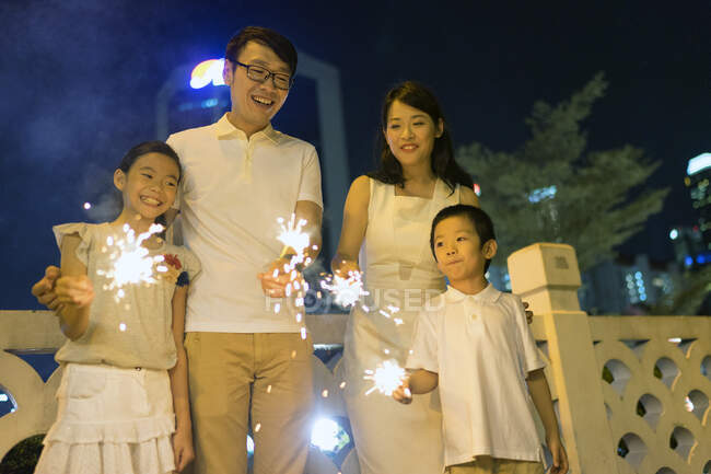 Young asian family together with sparklers at Chinese New Year — Stock Photo