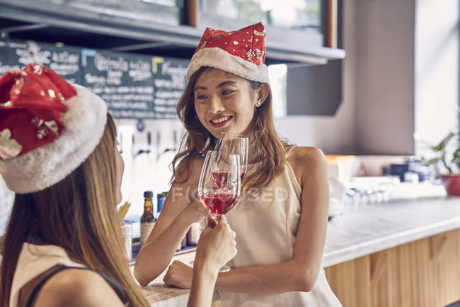 Feliz joven asiático mujeres amigos celebrando Navidad juntos en café - foto de stock