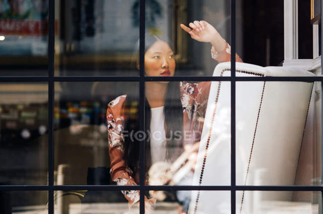 Piuttosto lungo capelli donna cinese ritratto in caffè attraverso la finestra — Foto stock
