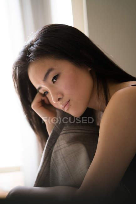 Портрет красивой китайской женщины в помещении рядом с окном с естественным освещением — стоковое фото