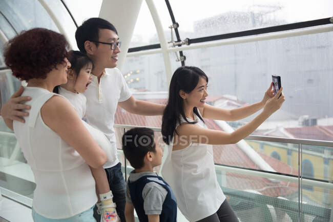 Una famiglia asiatica di tre generazioni si fa un selfie in un centro commerciale — Foto stock