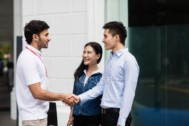 Salesperson speaking to couple on the street — Stock Photo