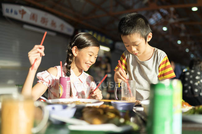 Young asian children together eating in cafe — Stock Photo