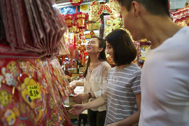 Young asian friends spending time together on traditional bazaar at Chinese New Year — Stock Photo