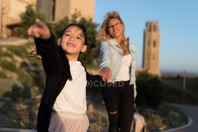 Retrato de la joven madre feliz con su hija disfrutando de la ciudad en un día soleado . - foto de stock