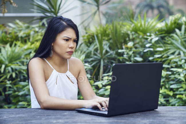 Junge malaiische Frau frustriert bei der Arbeit an ihrem Laptop — Stockfoto