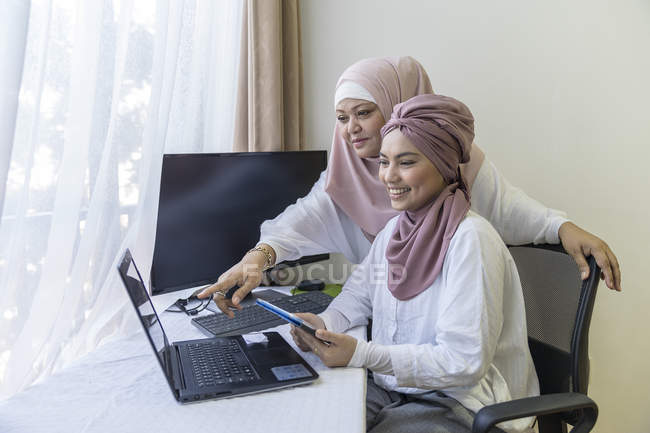 Mother and daughter working together at home — Stock Photo