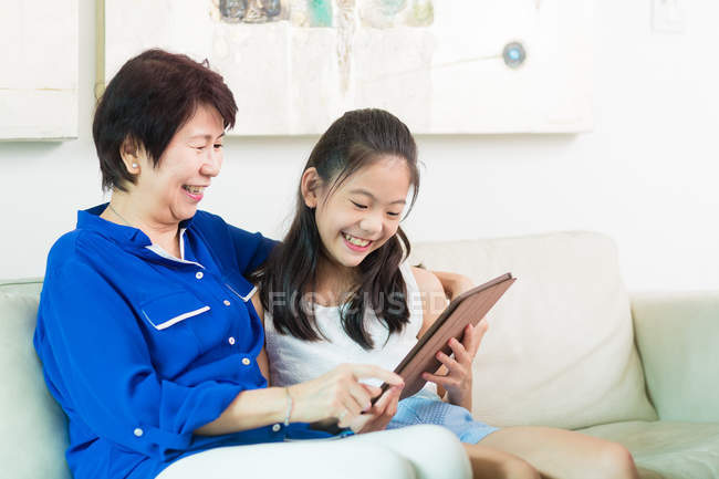 Grandmother and grandchild using a tablet together. — Stock Photo