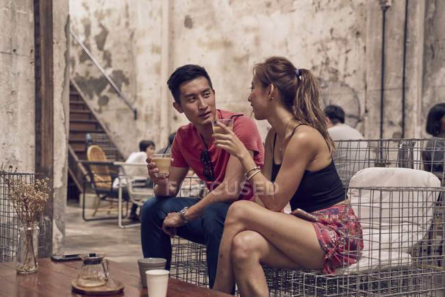 Feliz jovem asiático casal beber no café — Fotografia de Stock