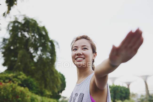 Молодая азиатская спортивная женщина делает растяжку на открытом воздухе — стоковое фото