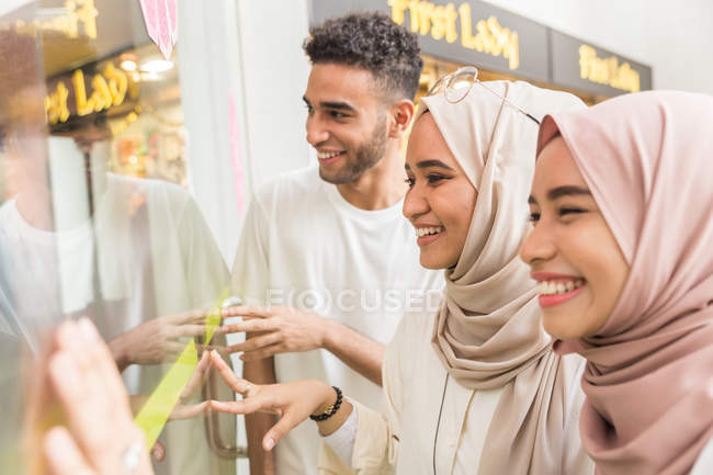 Young muslims looking into window — Stock Photo