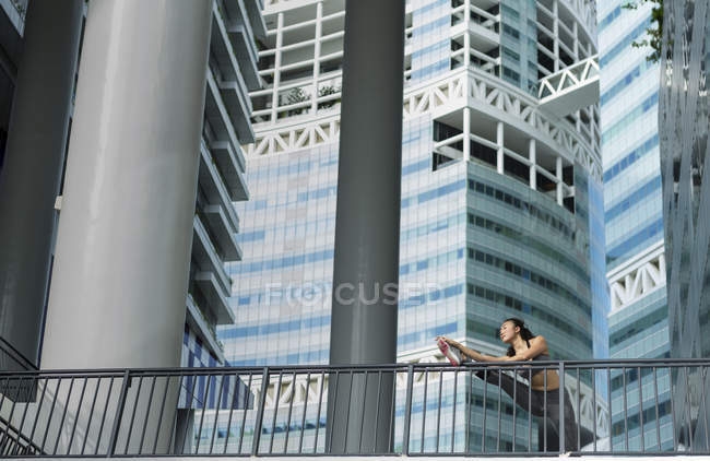 Молодая азиатка растягивается перед ежедневной тренировкой в Сингапуре — стоковое фото