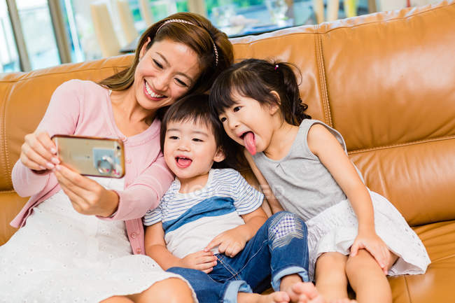 Mère et les enfants prennent un selfie à la maison — Photo de stock