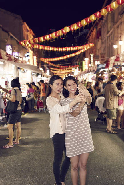 Jovem feliz asiático amigos passando tempo juntos no chinês ano novo e tomando selfie — Fotografia de Stock
