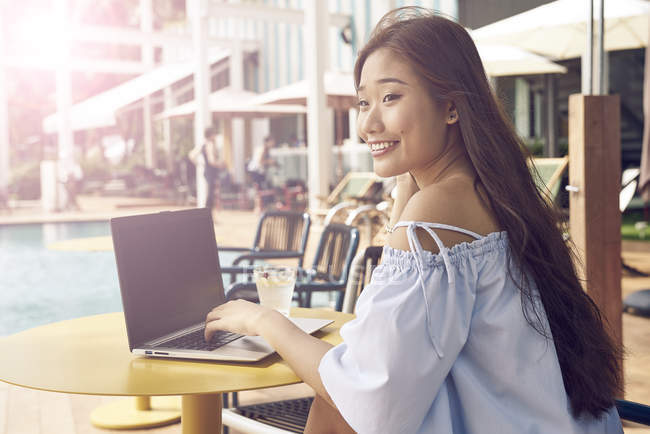 Attraktive junge asiatische Frau arbeitet mit Laptop — Stockfoto