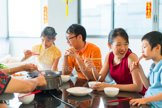 Feliz asiático familia comer juntos en mesa - foto de stock