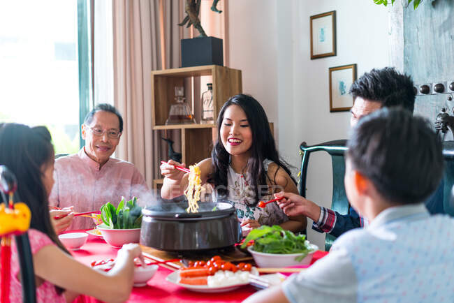 Felice famiglia asiatica insieme mangiare a casa — Foto stock