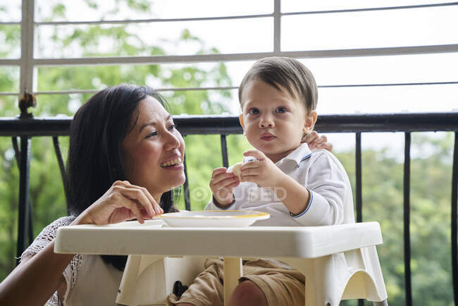 Madre vinculándose con su hijo en el balcón - foto de stock