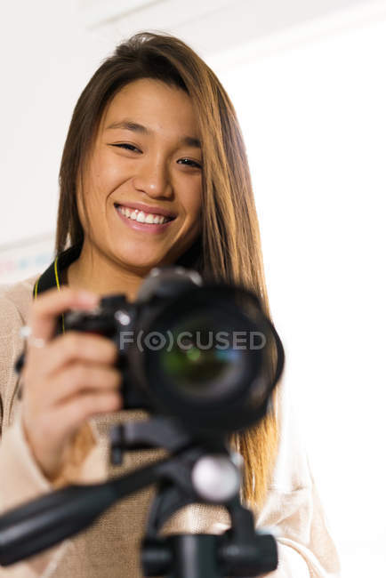 Portrait of young adult chinese woman with her camera — Stock Photo