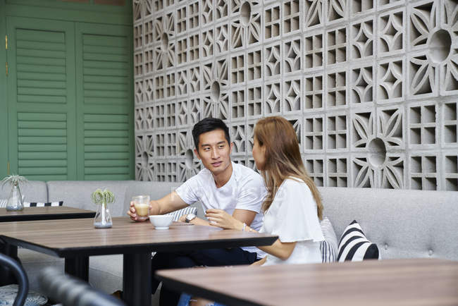 Young attractive asian couple together sitting in cafe — Stock Photo