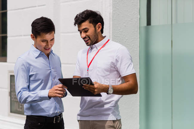Personas de negocios que hablan con el hombre en un cargo moderno - foto de stock