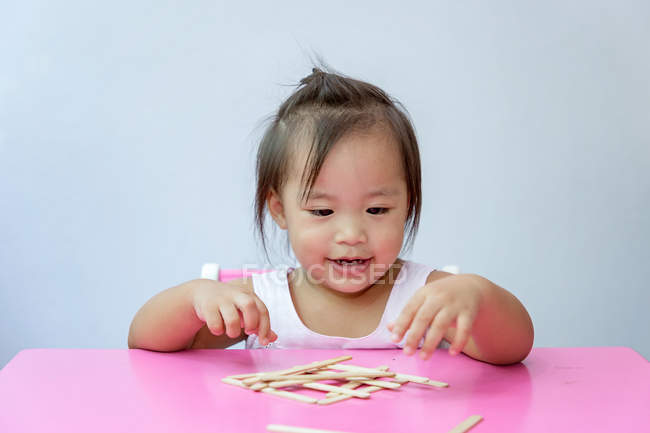 Joven poco asiático niño chica jugando con educativo juguetes - foto de stock
