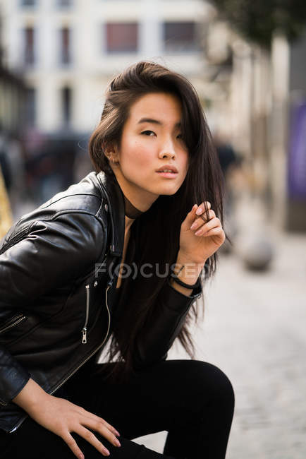 Giovane e bella ragazza cinese in Plaza Mayor di Madrid, Spagna, indossando una giacca di pelle — Foto stock
