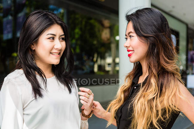 Young women hanging out together and having fun shopping in Orchard Road, Singapore. — Stock Photo