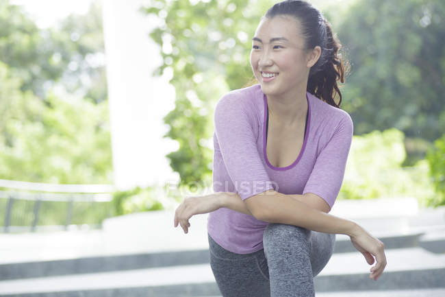 Eine junge asiatische Frau dehnt sich vor ihrem täglichen Lauftraining — Stockfoto