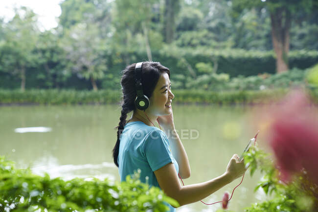 Portrait of woman listening to music while walking in Botanic Gardens — Stock Photo