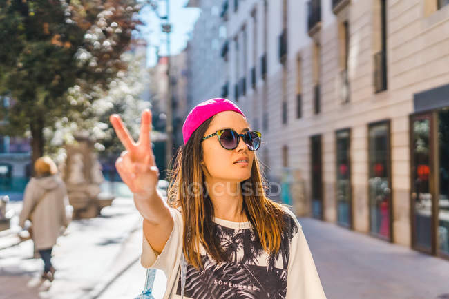 Young attractive asian woman showing peace gesture — Stock Photo