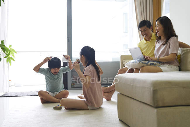 Felice giovane famiglia asiatica insieme trascorrere del tempo a casa — Foto stock