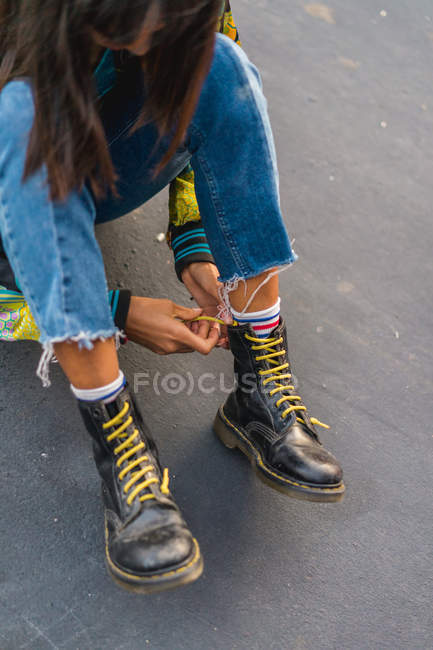Joven asiático mujer atando cordones de zapatos, primer plano - foto de stock
