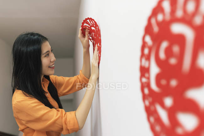 Giovane donna asiatica che celebra il capodanno cinese e decorare la casa — Foto stock