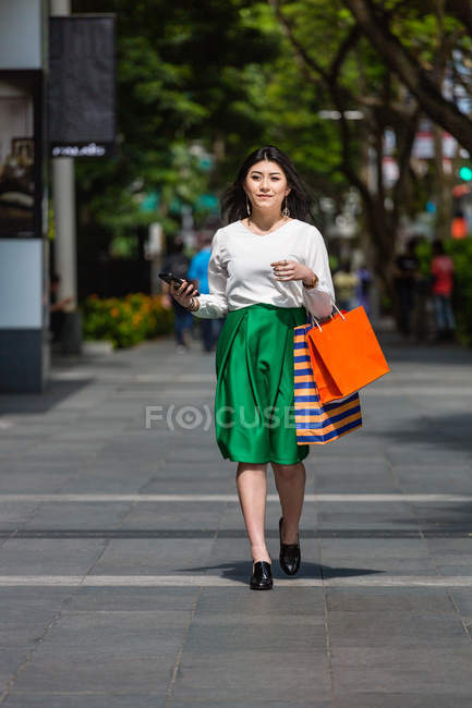 Mujer joven caminando y comprando por Orchard Road en Singapur . - foto de stock