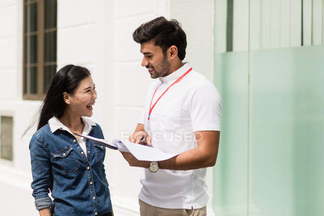 Male salesperson talking to woman outdoors — Stock Photo