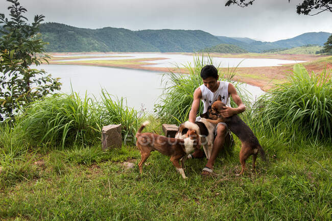 Un ragazzo con il suo cane accanto al lago Barapani di Meghalaya in India. — Foto stock