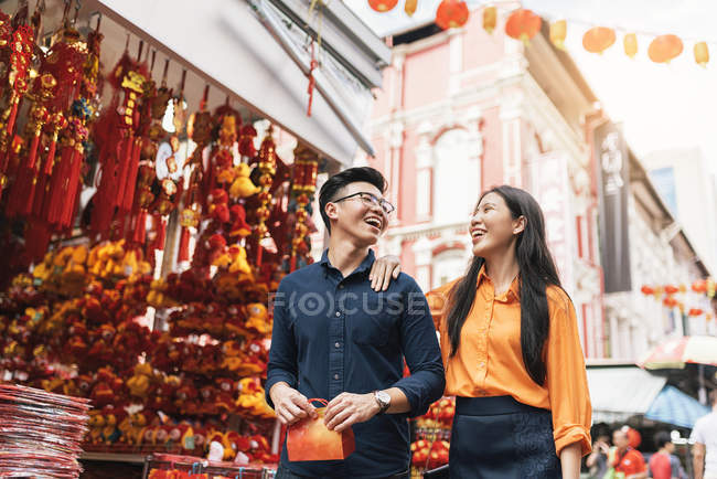 Joven feliz asiático pareja celebrando chino nuevo año juntos en chinatown - foto de stock